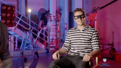 A student dressed as a burglar is being interviewed